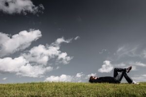 man laying on grass looking up at sky