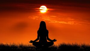 Woman in yoga pose outside at sunrise